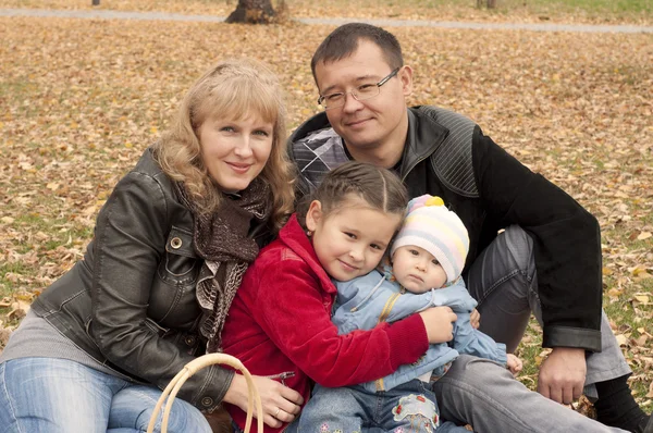Молодая семья в осеннем парке — стоковое фото