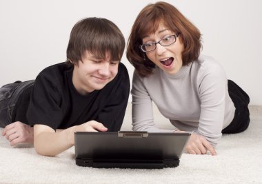 Anne ve oğul birlikte, bilgisayarla birlikte çalışmasına