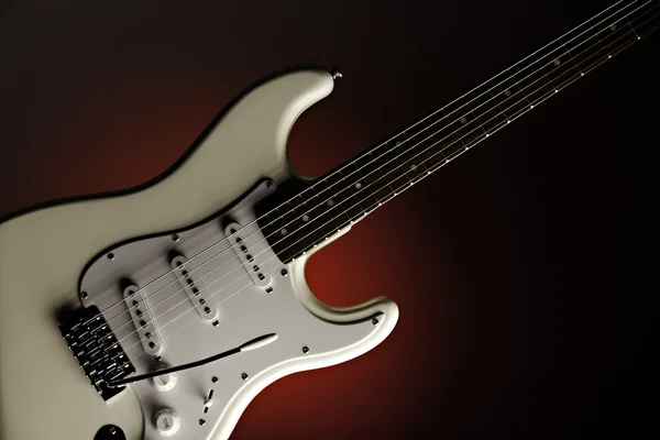Guitarra branca isolada no holofote vermelho — Fotografia de Stock