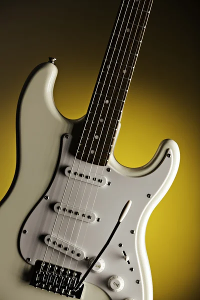 Guitarra branca isolada no holofote amarelo — Fotografia de Stock