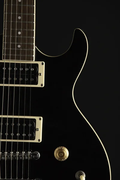 Черная электрическая гитара на чёрном — стоковое фото