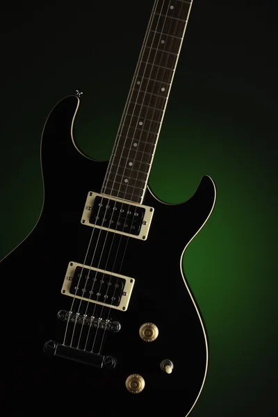 Черная электрическая гитара на зеленом — стоковое фото