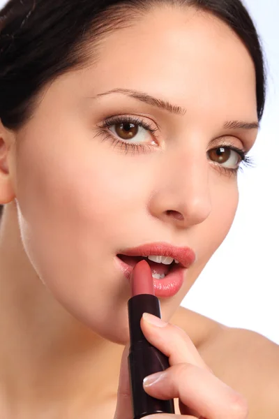 Hermosa mujer joven lápiz labial cosméticos a los labios — Foto de Stock