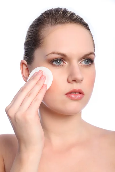 Menina bonita usando cosméticos almofada de algodão no rosto — Fotografia de Stock