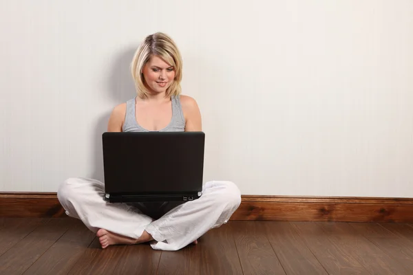 Happy young girl on floor surfing internet at home — Stock Photo, Image