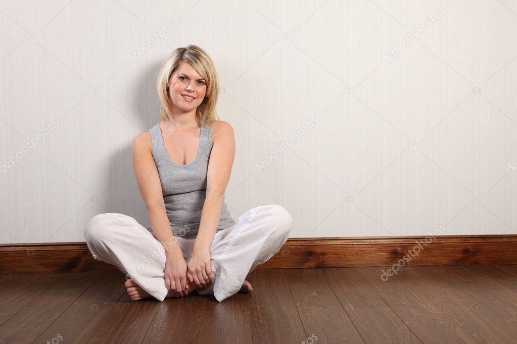 Casual young blonde woman at home in grey vest