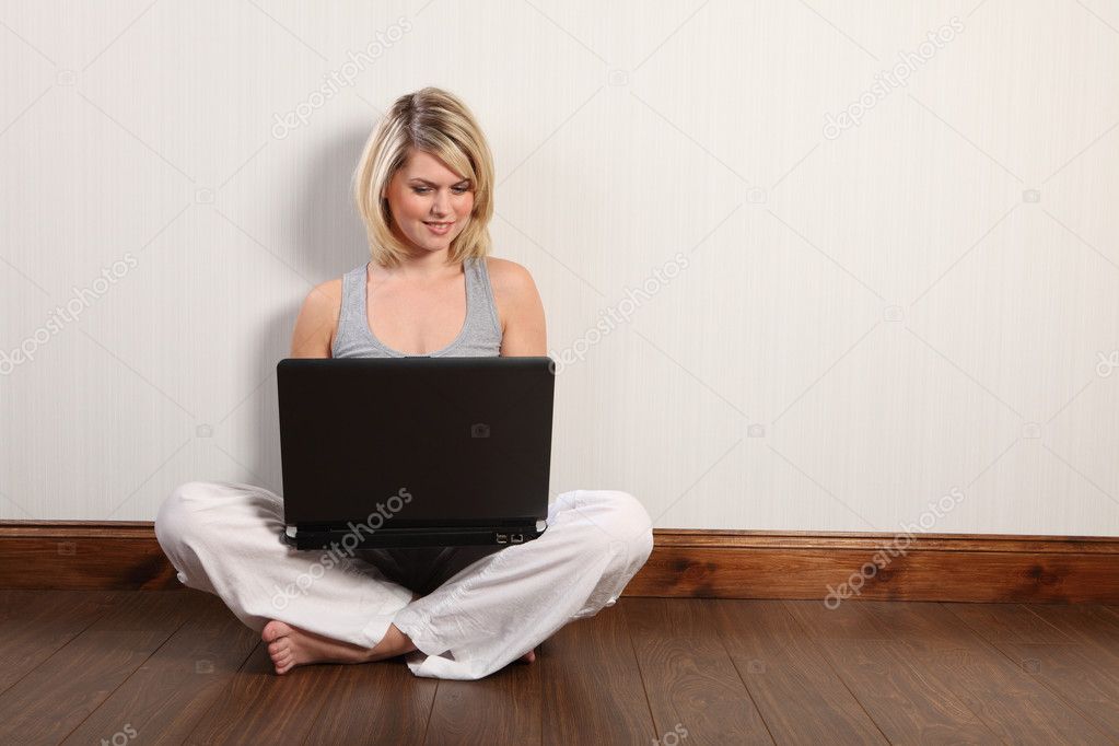 Happy young girl on floor surfing internet at home