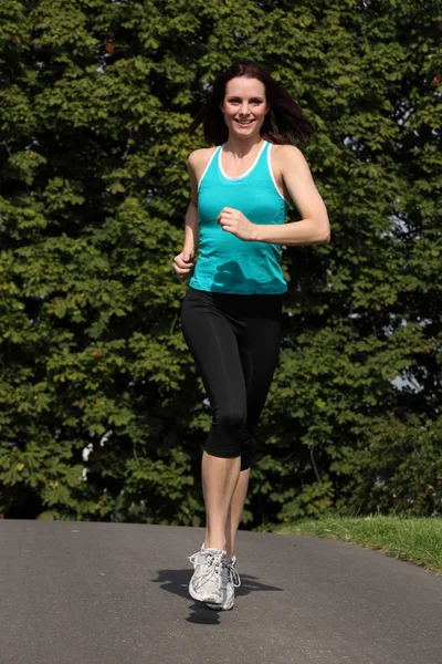 Счастливая женщина бег трусцой упражнения в парке солнце — стоковое фото