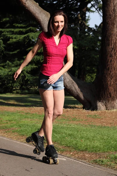 长腿高个女孩有好玩滚轴溜冰 — 图库照片