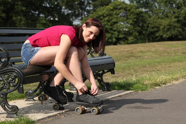 Tiempo divertido en sol hermosa chica poner en patines — Foto de Stock