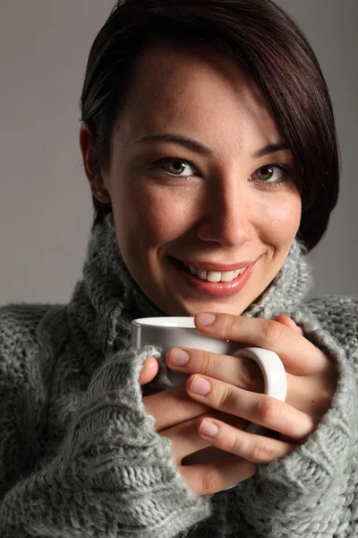 Beautiful young woman keeps warm drinking coffee — Stock Photo, Image