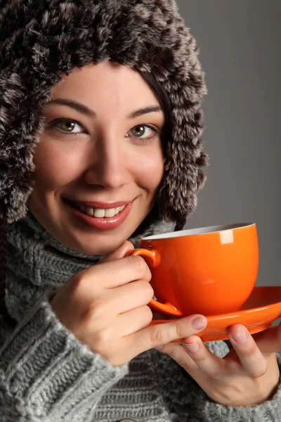 차를 마시는 따뜻한 양 털 모자에 있는 아름 다운 여자 — 스톡 사진