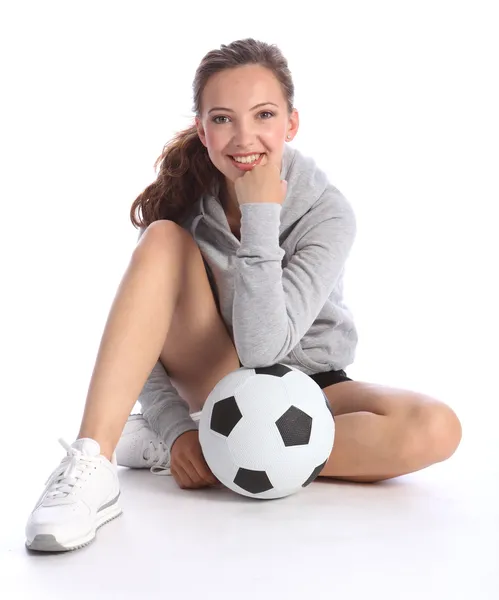 Счастливая девочка футболистка сидит с мячом — стоковое фото