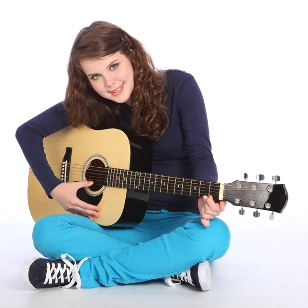 Mignon sourire par adolescent fille sur guitare acoustique — Photo
