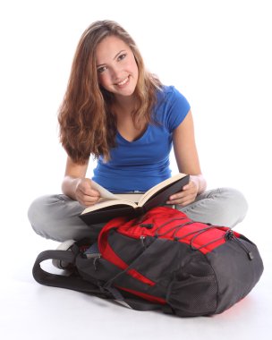 Genç öğrenci kız okul çalışma kitabı okurken