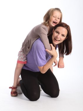 Happy mother giving daughter fun piggy back ride clipart