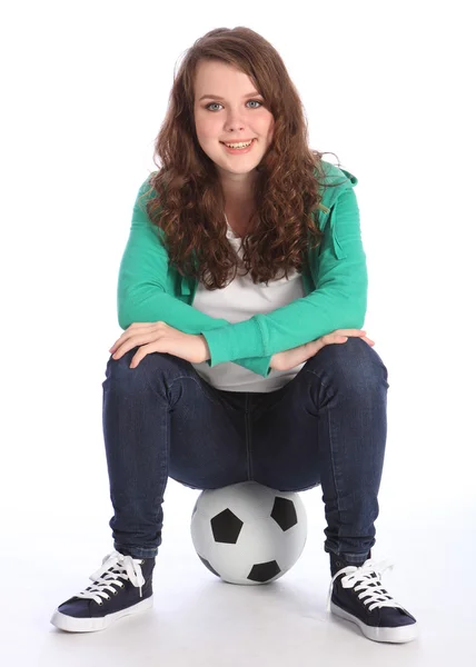 На мяче веселая девочка-подросток футболистка — стоковое фото