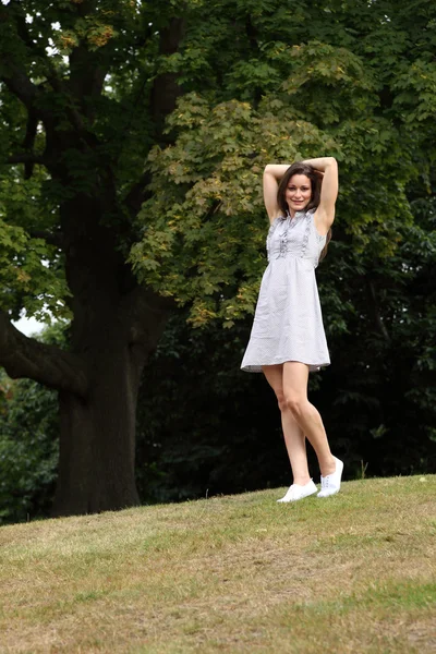 Junge Frau kurzes Sommerkleid steht im Wald — Stockfoto