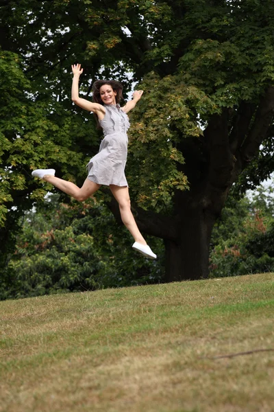 High flying jump for joy beautiful girl in park — Stock Photo, Image