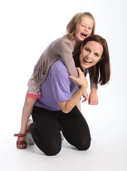 Счастливая мать дарит дочери веселое путешествие на спине — стоковое фото
