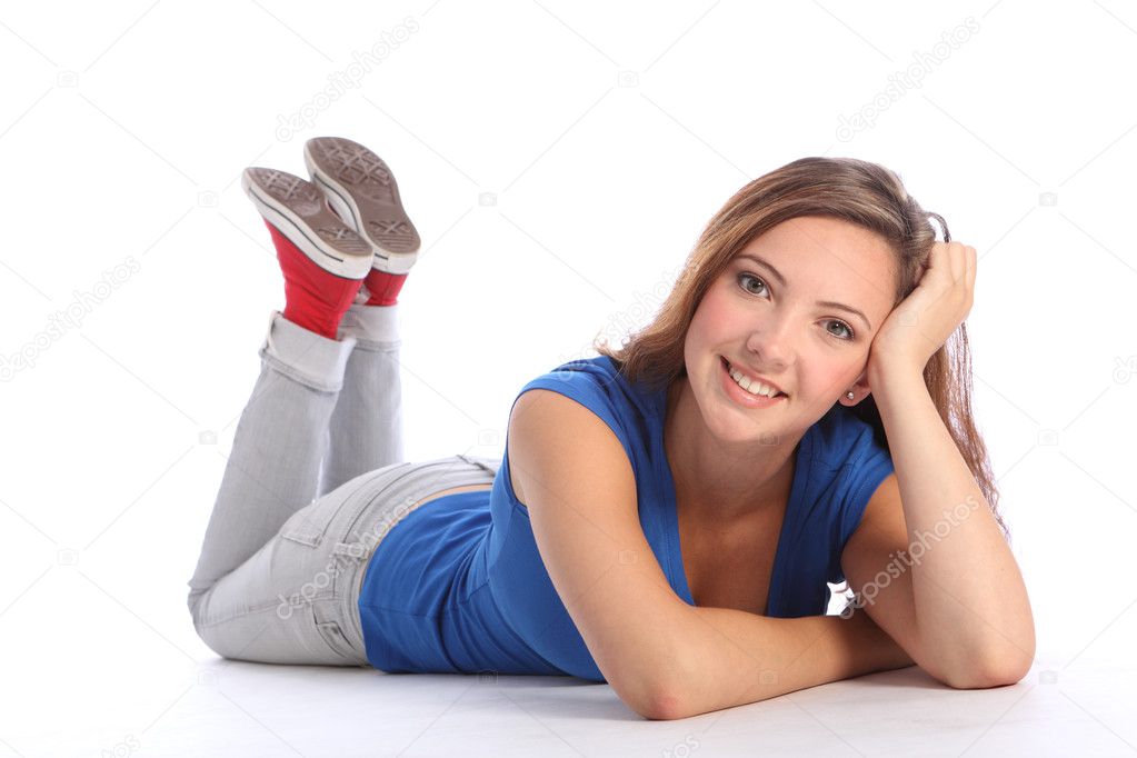 Happy pretty teenage school girl lying on floor