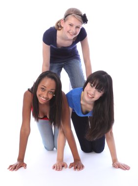 Mixed race teenage girl friends in fun pyramid clipart