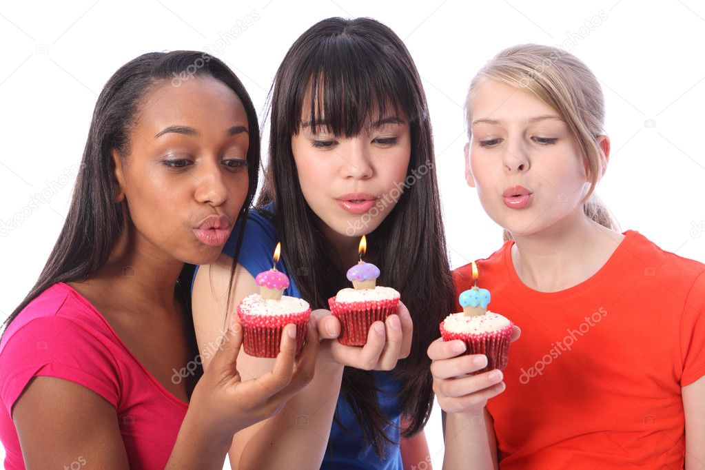 Teenage girl friends blowing out birthday candles