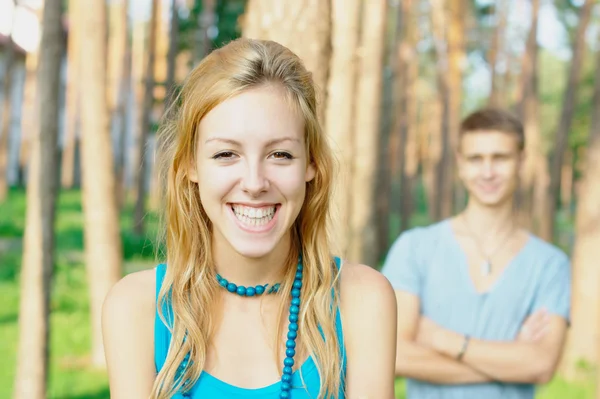 Glückliches junges Mädchen und ein Junge im Hintergrund — Stockfoto