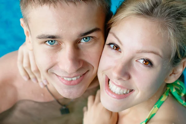 Smilende ungt par ved bassenget – stockfoto