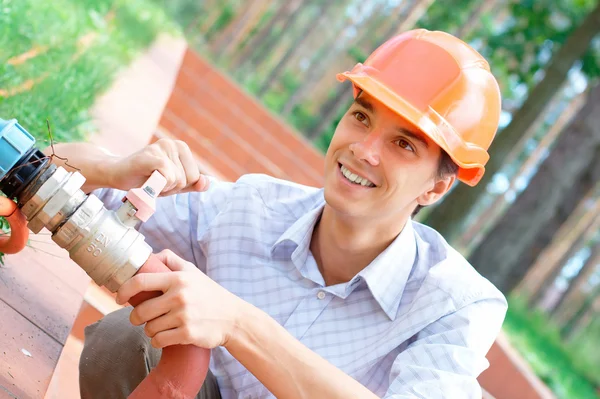 Усміхнений працівник ремонтує трубу Ліцензійні Стокові Фото