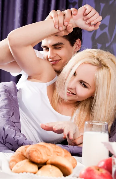 Unga par äter frukost på sängen — Stockfoto