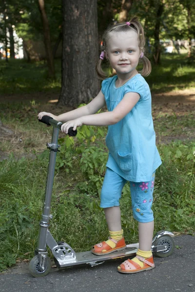 Menina sortuda para andar no parque em scooter — Fotografia de Stock
