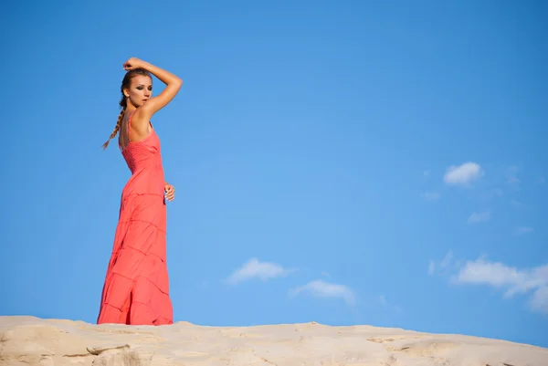Γυναίκα ομορφιά στο κόκκινο φόρεμα σε έρημο — Φωτογραφία Αρχείου