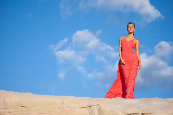 Красуня в червоній сукні на пустелі — стокове фото