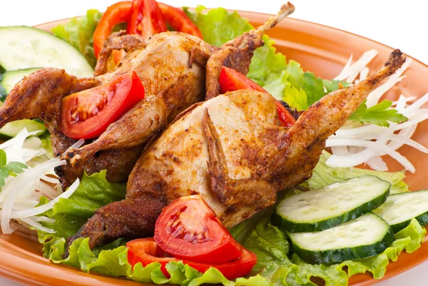 Two whole quail with cucumber, tomatoes and onion