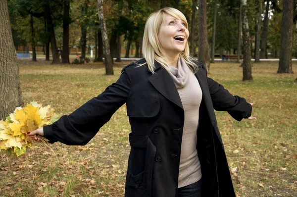 Счастливая женщина в осеннем парке — стоковое фото