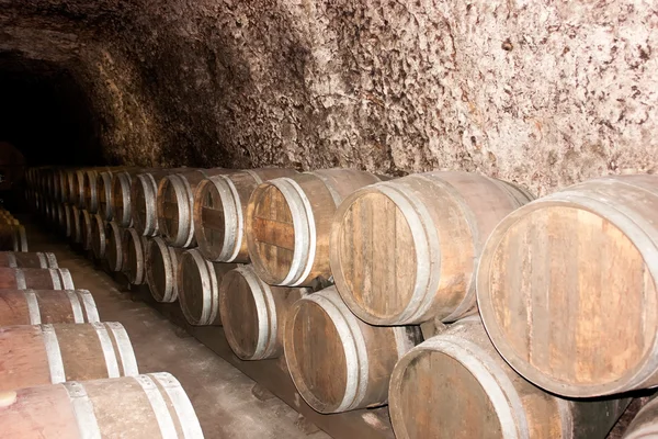 stock image Old wine barrels in a wine cellar