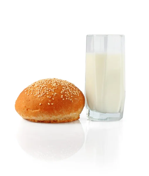Milk in glass and roll — Stok fotoğraf