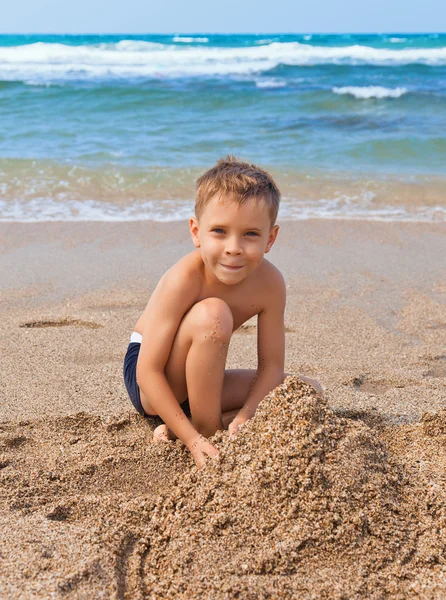 Pojke på stranden med sand — Stockfoto