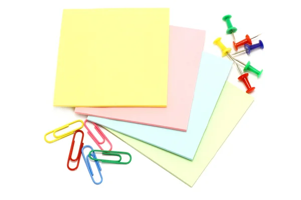 Papel colorido com alfinetes de desenho e clipes — Fotografia de Stock