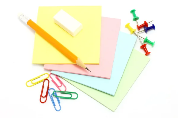 Papel colorido com alfinetes de desenho e clipes e lápis — Fotografia de Stock