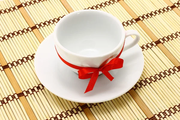 Kırmızı yay ile beyaz fincan — Stok fotoğraf
