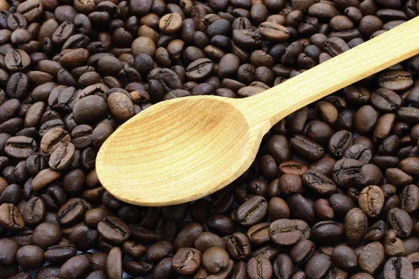 Kávová zrna s dřevěnou lžící — Stock fotografie
