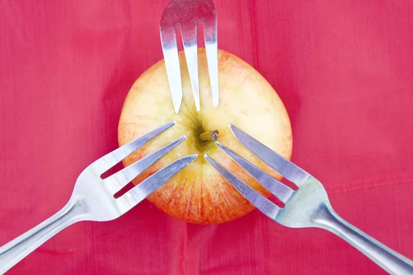 Manzana roja sobre rojo con tres tenedores — Foto de Stock