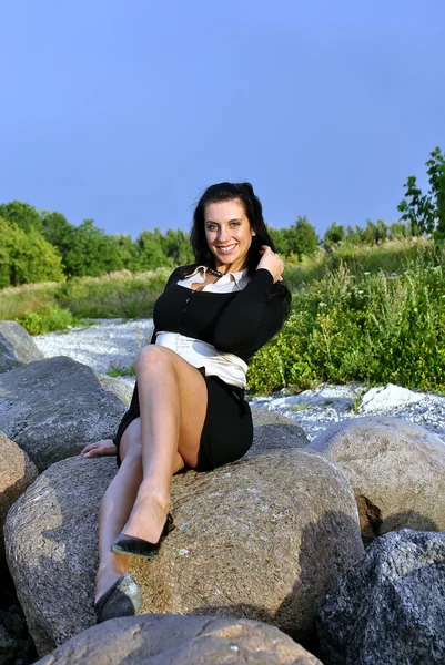 女孩坐在石头上，微笑 — 图库照片