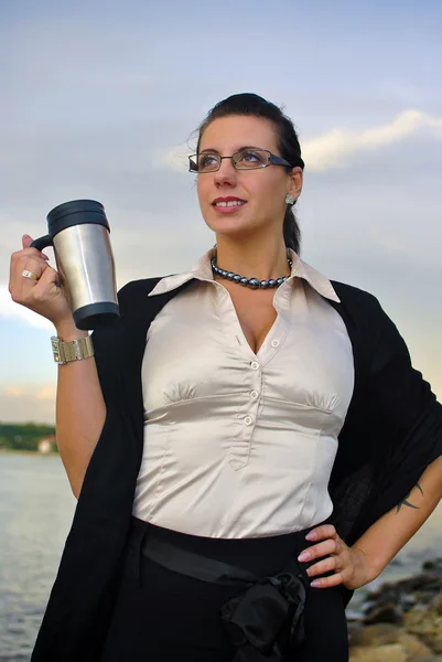 Dívku v brýlích s kávou stojí proti moři — Stock fotografie