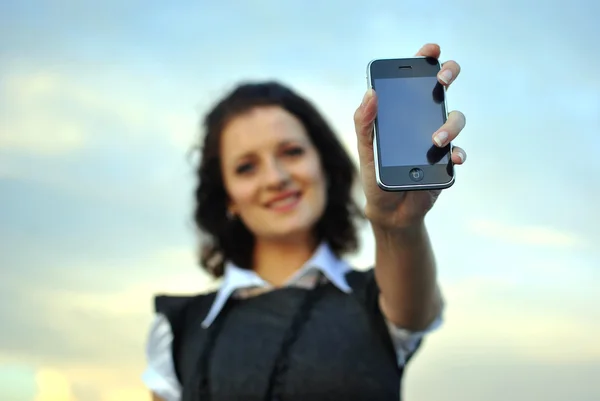 Mooie jonge vrouw tonen mobiele telefoon. gericht op de telefoon. — Stockfoto