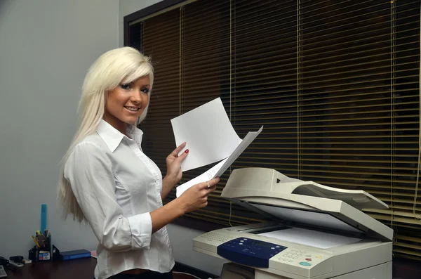 Pretty girl scans documents at the office — Stock Photo, Image