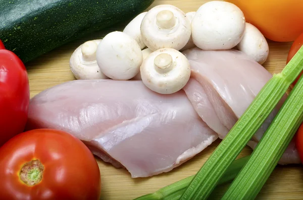 Курица и овощи на разделочной доске, крупный план — стоковое фото