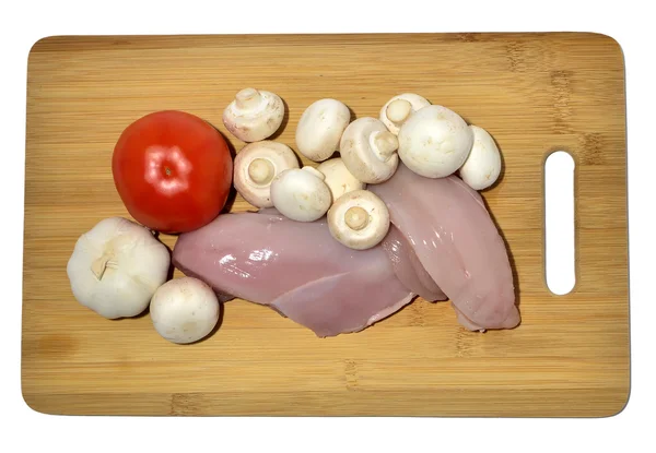 Курица и овощи на разделочной доске, изолированные на белом — стоковое фото